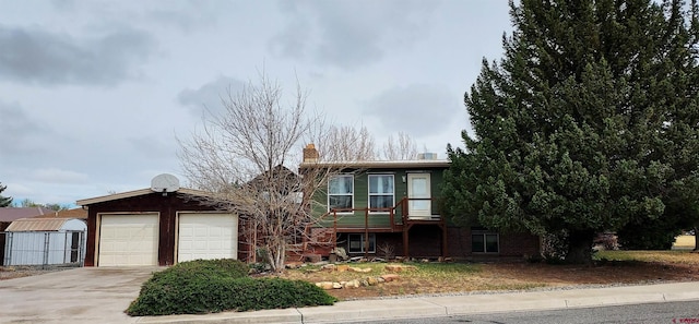 view of front facade featuring a garage, a chimney, driveway, and brick siding