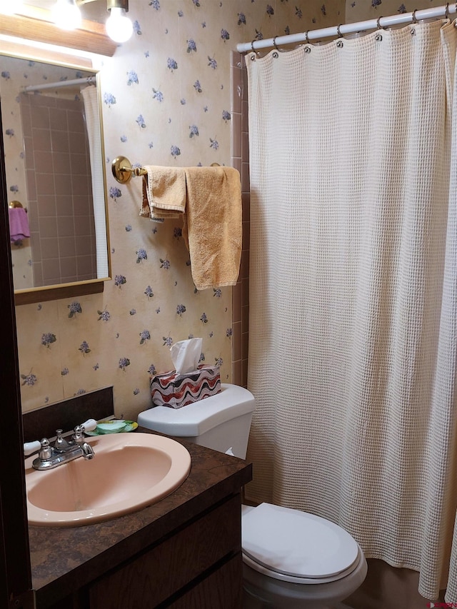 full bath with toilet, wallpapered walls, and vanity