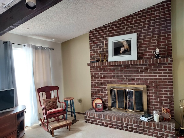 living area featuring carpet floors, a textured ceiling, and a fireplace