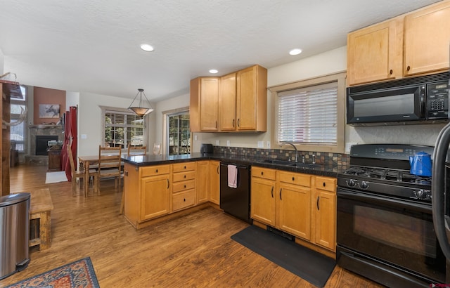 746 W Vallecito Crk, Bayfield, CO 81122 - kitchen featuring dark wood-style flooring, a sink, tile counters, a peninsula, and black appliances