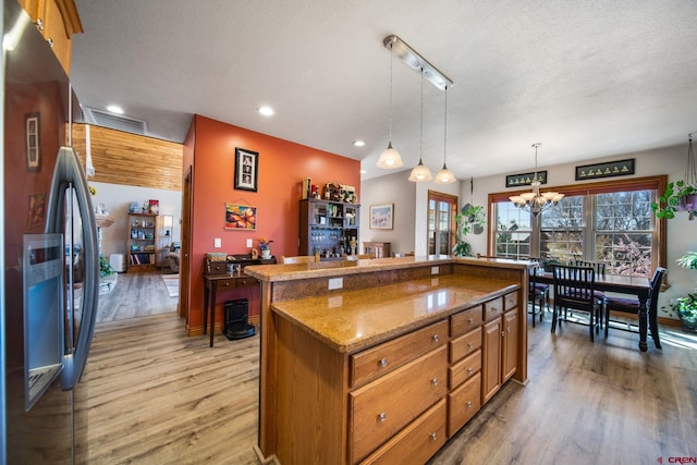 500 Dove Ranch Rd, Bayfield, CO 81122 - kitchen with stainless steel fridge, brown cabinetry, light wood finished floors, and a notable chandelier