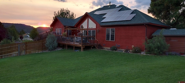 500 Dove Ranch Rd, Bayfield, CO 81122 - rear view of house with a shingled roof, roof mounted solar panels, a wooden deck, and a yard