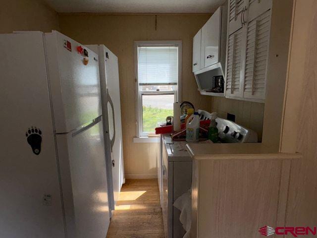 231 3rd Ave, Ouray, CO 81427 - kitchen with freestanding refrigerator, light wood-style floors, baseboards, light countertops, and white cabinets