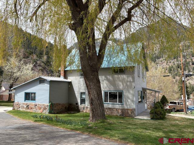 231 3rd Ave, Ouray, CO 81427 - view of property exterior featuring a lawn and stone siding