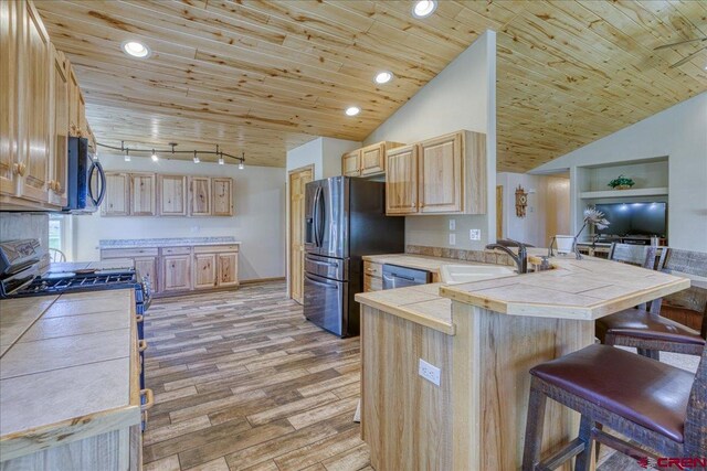 26 Steamboat Dr, Pagosa Springs, CO 81147 - kitchen featuring a peninsula, light brown cabinets, a breakfast bar area, a sink, and stainless steel appliances