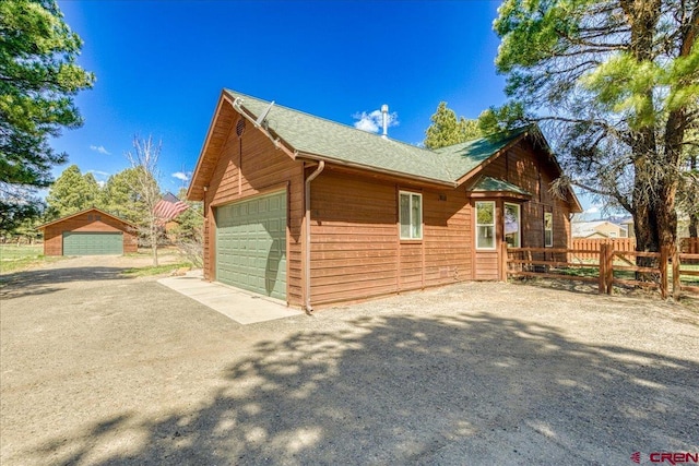 26 Steamboat Dr, Pagosa Springs, CO 81147 - view of side of home featuring fence, a garage, and aphalt driveway