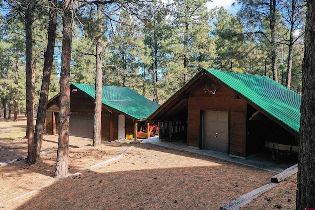 1215 Beaver Creek Dr, Bayfield, CO 81122 - view of front facade with metal roof, an outdoor structure, and a garage