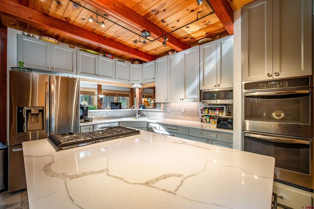 1215 Beaver Creek Dr, Bayfield, CO 81122 - kitchen featuring appliances with stainless steel finishes, light stone counters, a sink, beamed ceiling, and wood ceiling