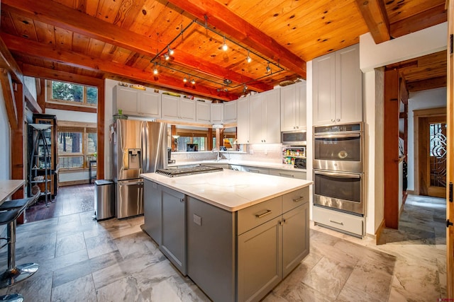 1215 Beaver Creek Dr, Bayfield, CO 81122 - kitchen with appliances with stainless steel finishes, beam ceiling, a kitchen island, gray cabinetry, and wood ceiling