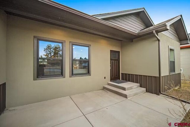 exterior space with stucco siding and a patio area