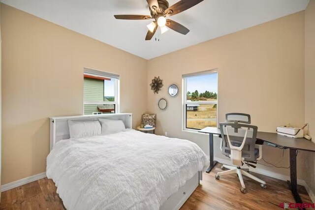 bedroom with baseboards, a ceiling fan, and wood finished floors