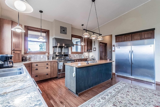 35900 Rd J.8, Mancos, CO 81328 - kitchen with wall chimney range hood, stainless steel appliances, light countertops, wood finished floors, and vaulted ceiling