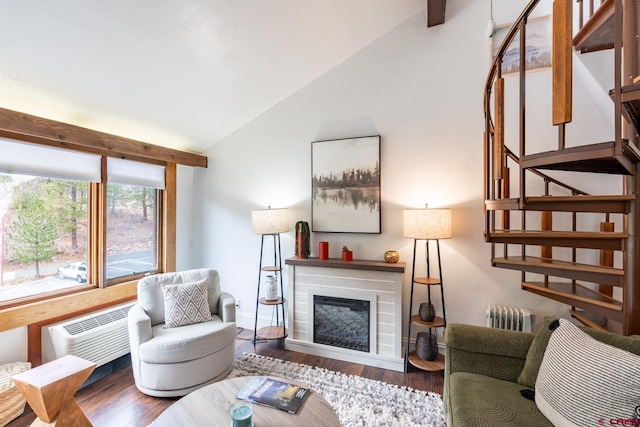 living area featuring a glass covered fireplace, radiator heating unit, stairs, wood finished floors, and lofted ceiling
