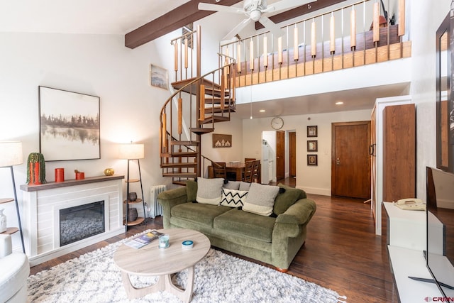 living room featuring stairs, radiator, wood finished floors, beamed ceiling, and a ceiling fan