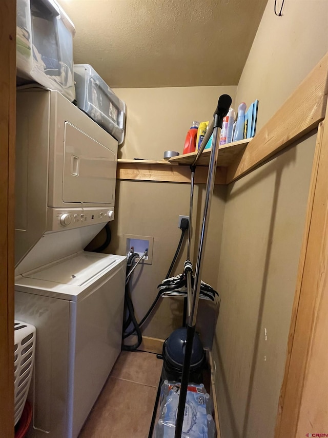 laundry room featuring stacked washer and dryer, laundry area, and tile patterned floors