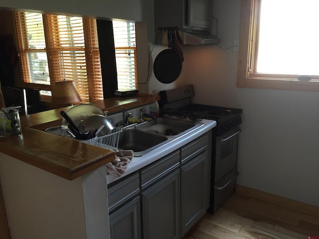 kitchen featuring light wood-style floors, a sink, and gas stove