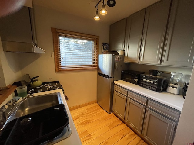 kitchen featuring light wood-style floors, light countertops, exhaust hood, and black microwave