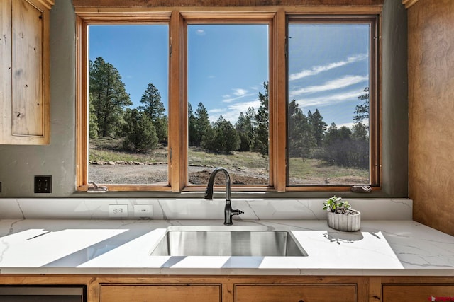 kitchen with a sink, backsplash, and brown cabinets