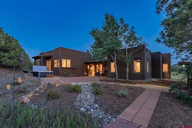 back of property featuring a patio and stucco siding