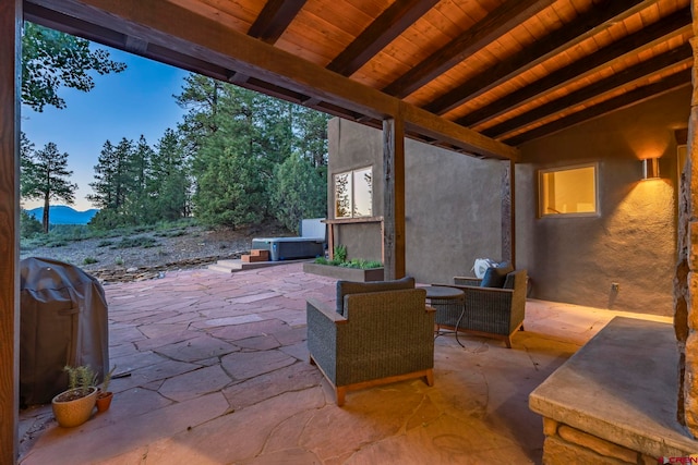 patio terrace at dusk with a hot tub and grilling area