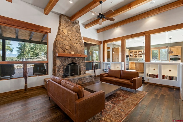living room with plenty of natural light, beamed ceiling, dark wood-style floors, and ceiling fan