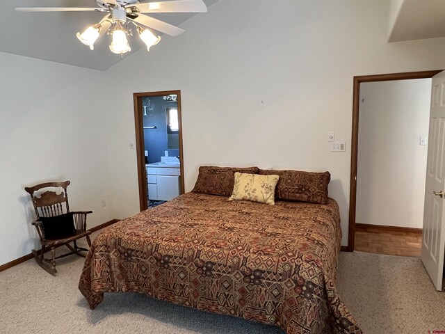 carpeted bedroom featuring baseboards, a ceiling fan, ensuite bath, and vaulted ceiling
