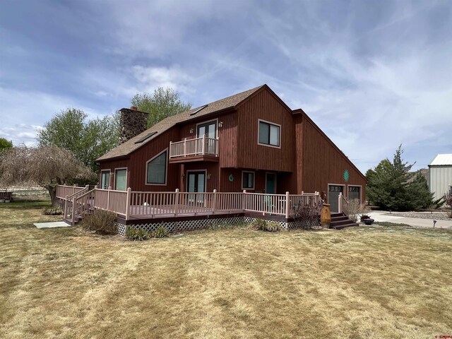 rear view of property featuring a deck, french doors, a balcony, and a chimney