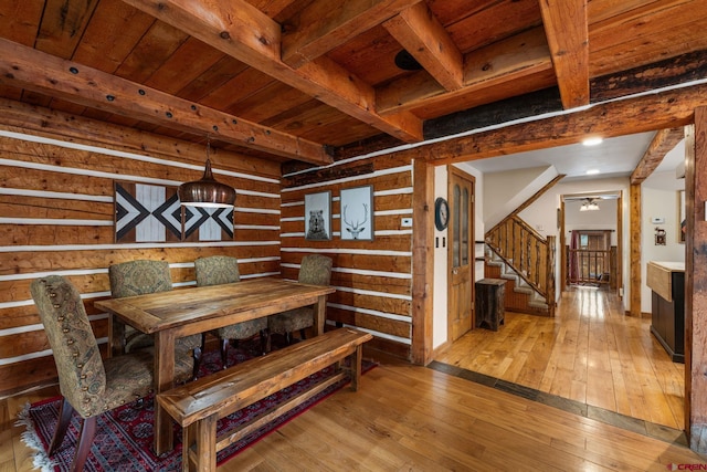 dining area featuring stairs, wood ceiling, hardwood / wood-style floors, and beamed ceiling