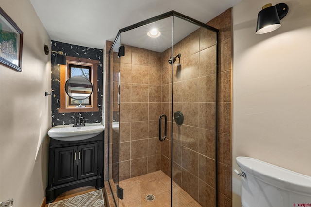 bathroom with vanity, a shower stall, and toilet