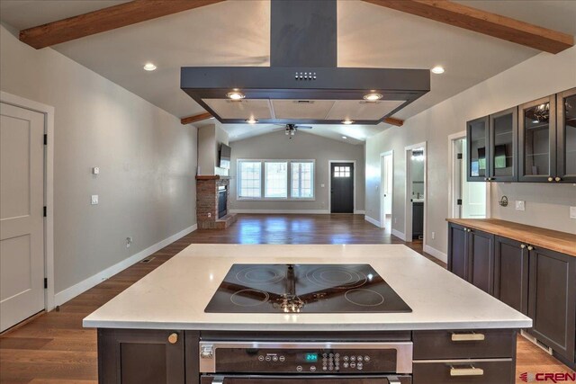 474 Lakewood St, Pagosa Springs, CO 81147 - kitchen with oven, lofted ceiling with beams, black electric cooktop, wood finished floors, and island range hood