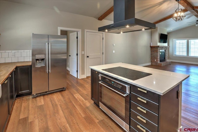 474 Lakewood St, Pagosa Springs, CO 81147 - kitchen with vaulted ceiling with beams, wood finished floors, island range hood, and stainless steel appliances