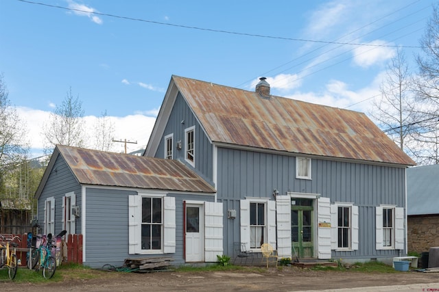 413 Second St, Crested Butte, CO 81224 - back of property featuring an outdoor structure, board and batten siding, a chimney, and metal roof