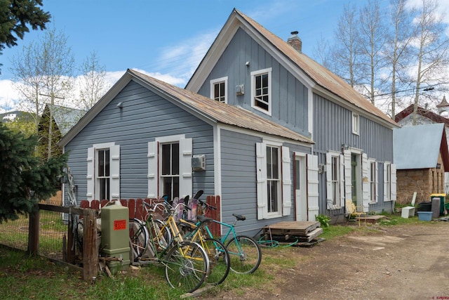 413 Second St, Crested Butte, CO 81224 - back of house with board and batten siding, fence, a chimney, and metal roof