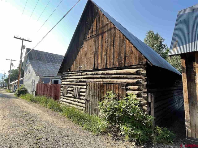 view of property exterior featuring fence and log siding