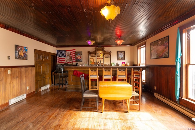dining room featuring a wainscoted wall, ornamental molding, and wood finished floors