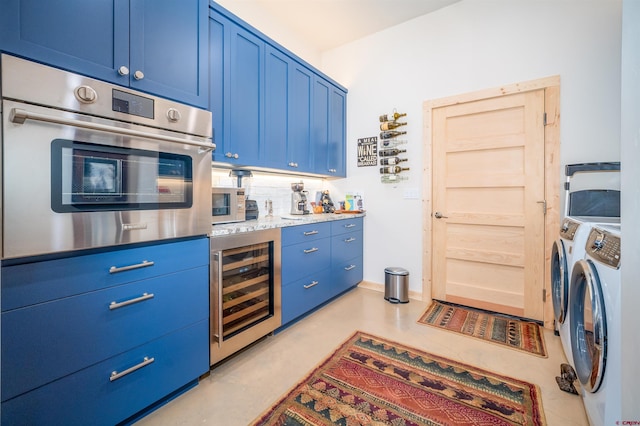 kitchen with washer and dryer, wine cooler, stainless steel oven, and blue cabinets
