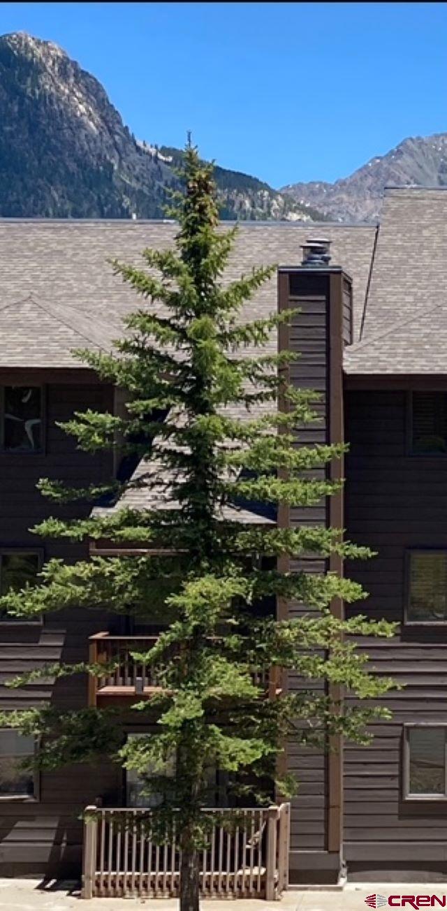 view of side of home with a mountain view and a chimney