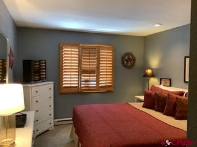 carpeted bedroom with a baseboard radiator