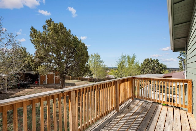 826 E Tamarack Dr, Bayfield, CO 81122 - wooden deck with a storage unit, a fenced backyard, and an outbuilding