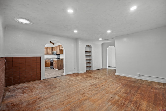 319 Rosevale Rd, Grand Junction, CO 81507 - unfurnished living room featuring recessed lighting, arched walkways, light wood finished floors, and baseboards