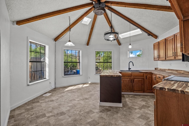 319 Rosevale Rd, Grand Junction, CO 81507 - kitchen with a sink, a textured ceiling, wood counters, brown cabinetry, and a ceiling fan