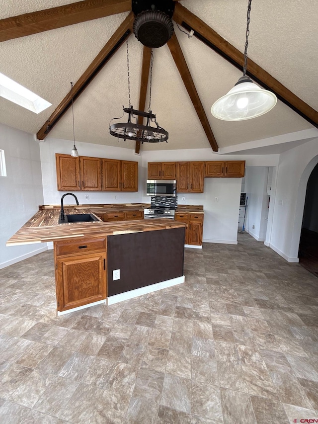 319 Rosevale Rd, Grand Junction, CO 81507 - kitchen with stainless steel appliances, baseboards, brown cabinetry, and a sink