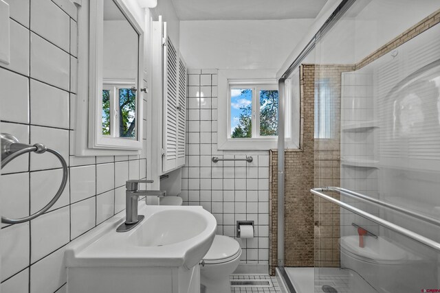 319 Rosevale Rd, Grand Junction, CO 81507 - full bath with vanity, toilet, tile patterned floors, tile walls, and a stall shower