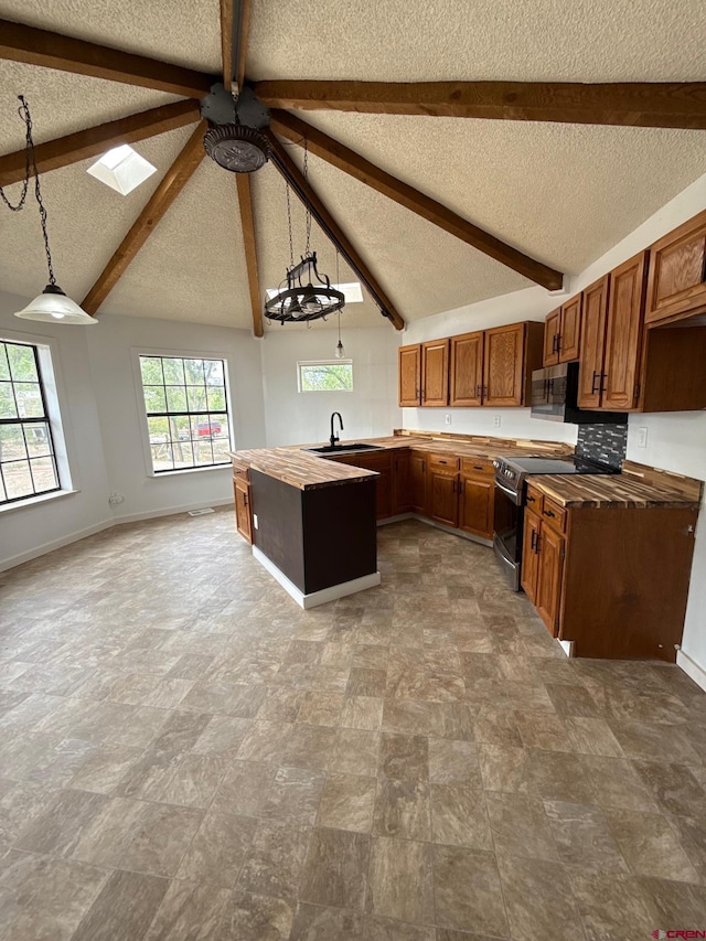 319 Rosevale Rd, Grand Junction, CO 81507 - kitchen with appliances with stainless steel finishes, a sink, a textured ceiling, wooden counters, and brown cabinetry