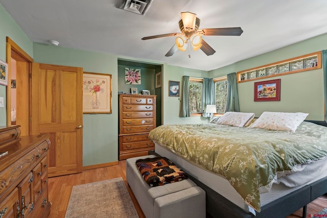 bedroom with a ceiling fan, baseboards, visible vents, and light wood-style flooring