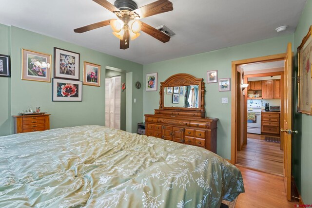 bedroom with ceiling fan, a closet, wood finished floors, and visible vents