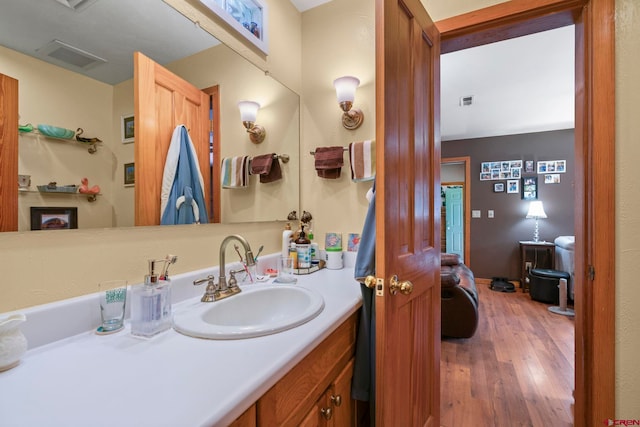 bathroom with vanity, visible vents, and hardwood / wood-style floors