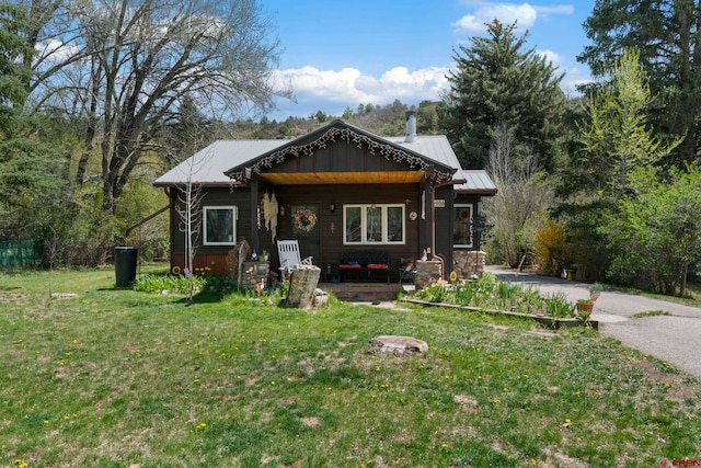 view of front of house with metal roof and a front yard