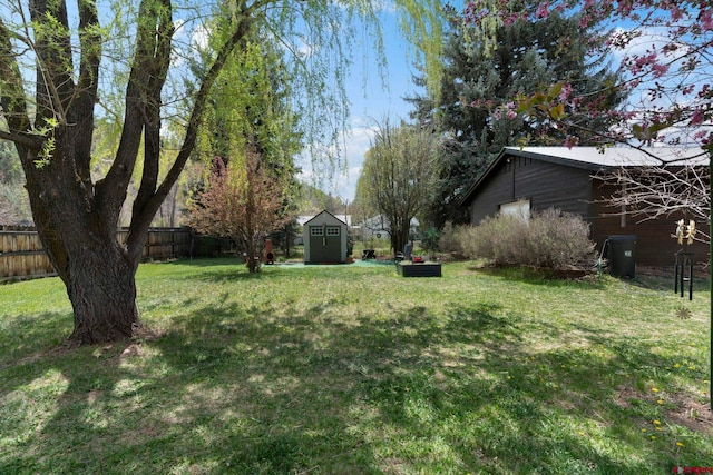 view of yard featuring an outdoor structure, a fenced backyard, and a storage shed