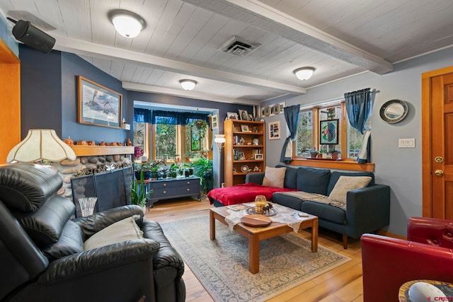 living area with visible vents, a fireplace, beam ceiling, wooden ceiling, and light wood-style floors
